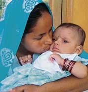 Jasbir Kaur cajoles her infant daughter.