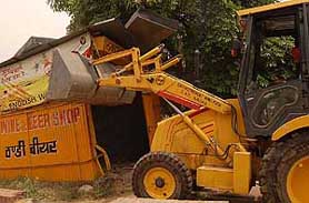 A JCB machine in action during the demolition of a liquor vend near the Mohali bus stand on Wednesday.