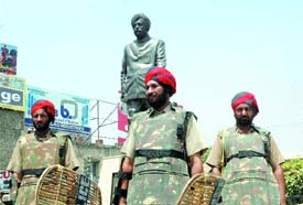 Policemen guard the statue of late Chief Minister Beant Singh at BMC Chowk in Jalandhar.