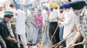 Activists of a Sikh organisation burn the effigy of the Sacha Sauda chief in Ludhiana
