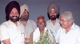 Dr. A.L. Adlakha, president of service club, Amritsar, honours gardener Muni Lal with lifetime service award.