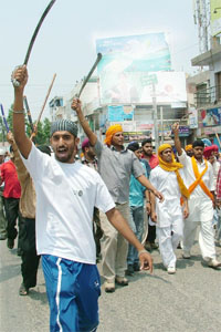 Sikh activists brandish swords as a show of strength.