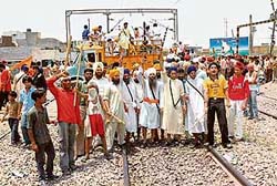 Activists of Damdami Taksal protest on the Jalandhar-Amritsar rail line at Subhanpur village in Kapurthala district