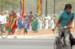 Women make use of their apparel to save their tresses from the heat wave and duststorm that have been a regular feature of the Capital in the past few days