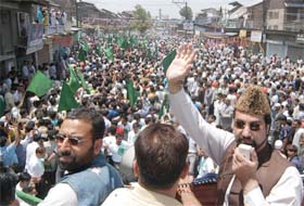 All-Party Hurriyat Conference chairman Mirwaiz Umar Farooq (hand raised) addresses a gathering during the death anniversary of his father Maulvi Mohammad Farooq, in Srinagar