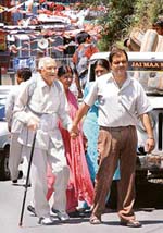 An old man being helped to reach a polling booth to exercise franchise for the MC elections in Shimla