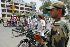 A BSF jawan keeps vigil at a crossing in Amritsar on Friday. Though the situation has calmed down, the government is not taking any chances.