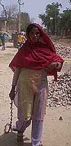 Rajjo Bai walks with her right leg and hand in chains.