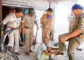 An old man being kicked and his hair pulled by the police in Sarguja district in Chattisgarh