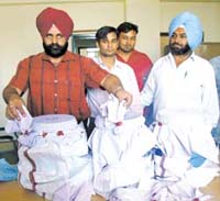 Personnel of Delhi Police Narcotics branch show 54 kg opium seized from Subhash Chander of Udhampur and Sharafat of Bikaner at Shakarpur police station in the Capital on Sunday