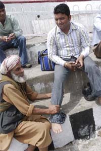 Wali Mohammed, who works as a porter, massages a tired pilgrim at the Mata Vashino Devi Shrine