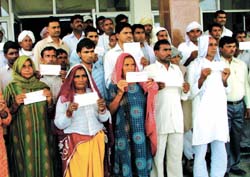 Farmers of Chand Nagar Ki Dhani village show the cheques they have received as compensation for damaged crops