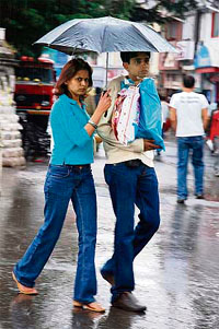 A couple takes cover under an umbrella as rain lashed Shimla on Monday.