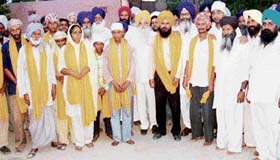Jagdish Garcha, former SAD minister, and Raghbir Singh Saharamajra pose with Sacha Sauda sect followers who returned to the Sikh fold