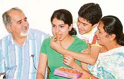 Jubilant parents and brother of Isha Hans offer sweets to her for topping the state in the All India Engineering Entrance Examination in Ludhiana
