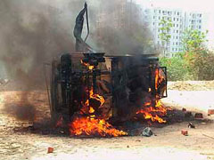 A police vehicle set on fire by protesters in Faridabad on Friday.