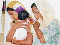 Binder Kaur and Kulwinder, wife and daughter of the alleged serial killer, Mewa Singh, at the press conference where he was presented before mediapersons in Ludhiana