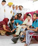 Hira Singh Gabria, minister for jails, printing and stationery, and a former minister Rakesh Pandey at an artificial limb distribution camp in Ludhiana on Sunday