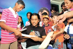 Children from various NGOs take autographs from M. S. Dhoni in the Capital