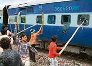 Gujjar youths damage a train in Chata village, Mathura; and two buses set on fire in New Delhi on Monday. 