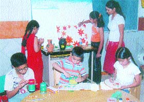 DIPS students colour their art pieces during a summer camp