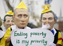 Activists from anti-globalisation organisation, Oxfam, dressed as Russian President Vladimir Putin and British Prime Minister Tony Blair in Pinocchio costumes pose for the media at harbour in Rostock.