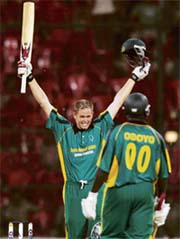Africa XIs Shaun Pollock celebrates his century as team-mate Thomas Odoyo looks on during the first one-day international against Asia XI at the Chinnaswamy stadium in Bangalore on Wednesday. 