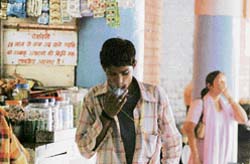 An underage smoker lights a cigarette at the ISBT, Sector 17, Chandigarh, as a woman covers her face