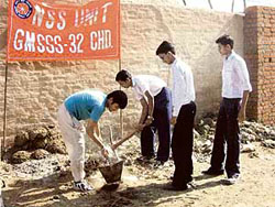NSS volunteers of GMSSS-32 take part in a cleanliness drive at Faida village, near Sector 48, Chandigarh, on Friday.