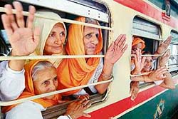 Sikh pilgrims wave after boarding a special train to Pakistan at the railway station in Amritsar