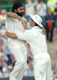 Englands Monty Panesar celebrates with Michael Vaughan after taking the wicket of the West Indies Darren Sammy on the second day of the third Test at Old Trafford, Manchester, on Friday.