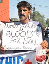 An electropathic doctor, carrying placards announcing blood for sale, protests against government doctors in Srinagar. 