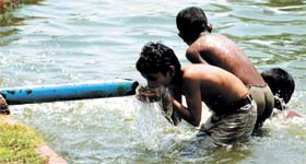 Boys cool off at India Gate as the temperature in the Capital rises to 44C