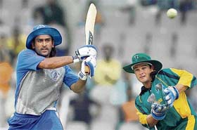 Asia XIs Mahendra Singh Dhoni plays a shot as Africa XIs Mark Boucher looks on during the third match of the Afro-Asia Cup at the M.A.Chidambaram in Chennai
