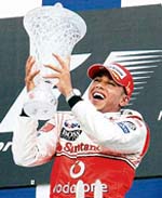 McLaren Mercedes driver Lewis Hamilton of Britain holds the trophy after winning the Canadian F1