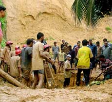 Bangladeshi rescue workers recover bodies after a landslide in Chittagong on Monday. Landslides and lightning strikes left dozens dead as torrential monsoon rain pounded the country. 