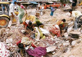 The poor try to salvage vegetables and fruits buried under the debris in the Grain Market, Sector 26, Chandigarh
