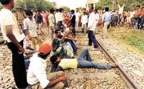 Villagers squat on the railway track at Shahbad Mohammad Pur in protest against the construction of a boundary wall at Indira Gandhi International Airport in the Capital