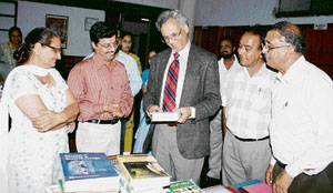 Dr M.S.Kang having a look at a book during his visit to M.S. Randhawa Library in Ludhiana on Tuesday.