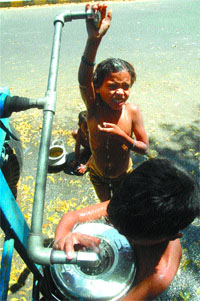 Children throng a roadside tanker in the Capital on Thursday.