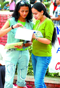 Students fill up their admission forms at Delhi University in the Capital on Friday.