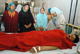 Relatives beside the hospital bed of a person who was injured in a grenade attack on a CRPF party at Badyara Ashtangoo