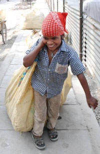 A minor carries a bag of discarded articles to make a living at Panipat.