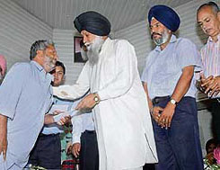 Minister for cooperation Kanwaljit Singh distributes insurance policies after the launch of Barish Bima Yojna in Patiala on Sunday.