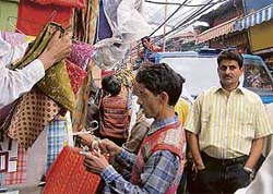 Workers of the municipal corporation remove encroachments in lower bazaar during an anti-encroachment drive in Shimla on Tuesday.