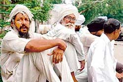 Farmers wait for migrant labourers outside the Rajpura railway station