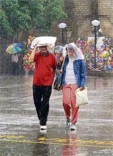 This couple is caught unawares on The Ridge as rain lashes Shimla on Wednesday.