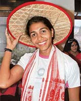 Indias ace long jumper Anju Bobby George wears a traditional Assamese japi, hat and gamocha on her arrival at Guwahati