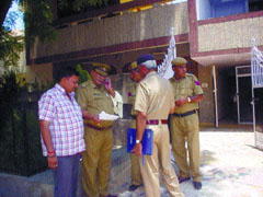 Police officers outside the house of the deceased.