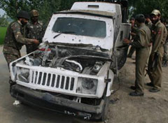 Army and police personnel inspect a damaged police vehicle after a landmine explosion at Maloora Shalteng on the outskirts of Srinagar on Sunday.